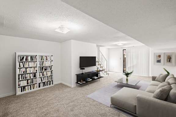 A living room with a grey couch, a television, and a bookshelf.