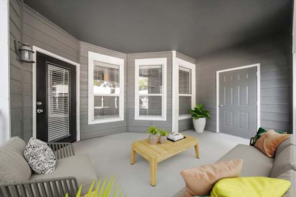 A living room with a grey couch, a wooden coffee table, and a grey wall. at Somerset Oaks Apartment Homes, Olathe, KS, 66062