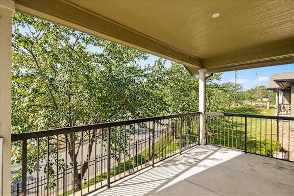 Large Balcony with black railing at Deer Creek Apartment Homes, Overland Park