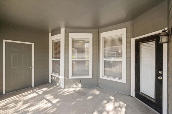 a front porch of a home with windows and a door