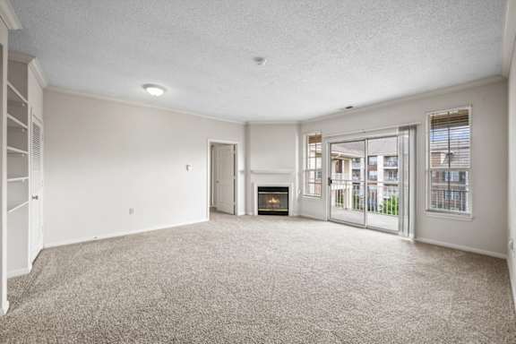 A spacious living room with a fireplace and sliding glass doors.at The Claremont Apartment Homes, Overland Park Kansas