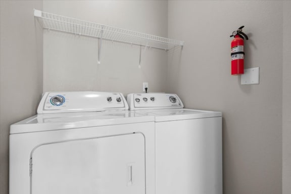 a white washer and dryer in a laundry room with a fire hydrant