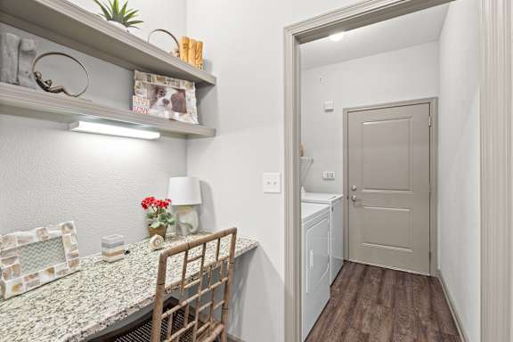 A small room with a chair and a table with a lamp.