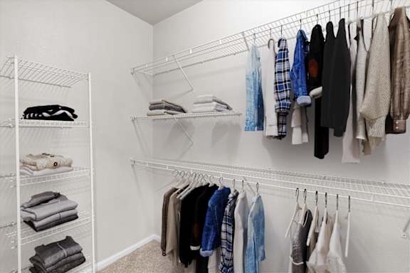 Large walk-in closets with shelves and clothes hanging at Deer Creek Apartment Homes, Overland Park, 66213