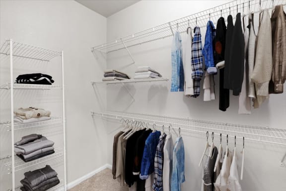 a closet with a rack of clothes hanging on the wall