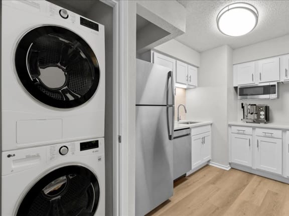 a white kitchen with a washing machine and a refrigerator