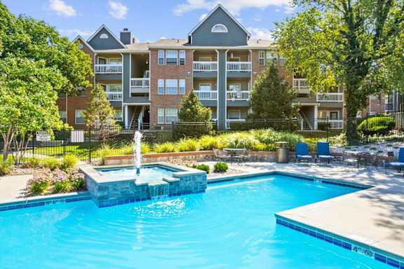 A large apartment complex with a pool and waterfall.