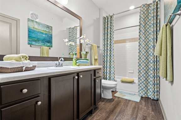 A bathroom with a white toilet, a sink, and a shower curtain.