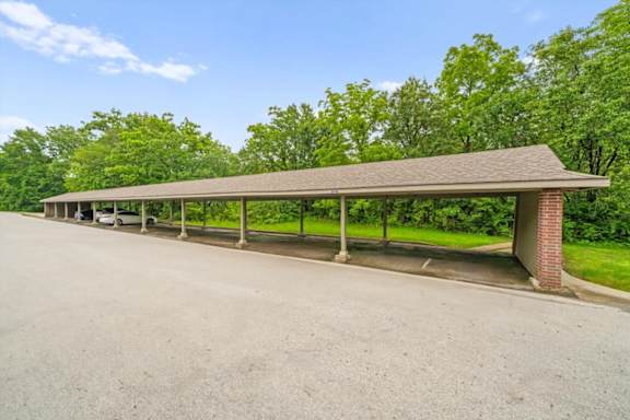 A long covered parking area with a brick pillar. at Coventry Oaks Apartments, Kansas, 66214