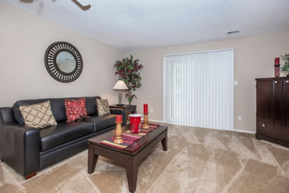Living room with black sofa and center table at Preston Court Apartments, Overland Park