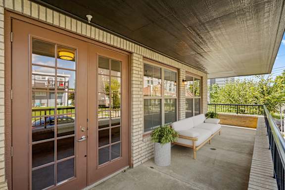 A large, private fenced-in balcony with two windows and beautiful French doors.