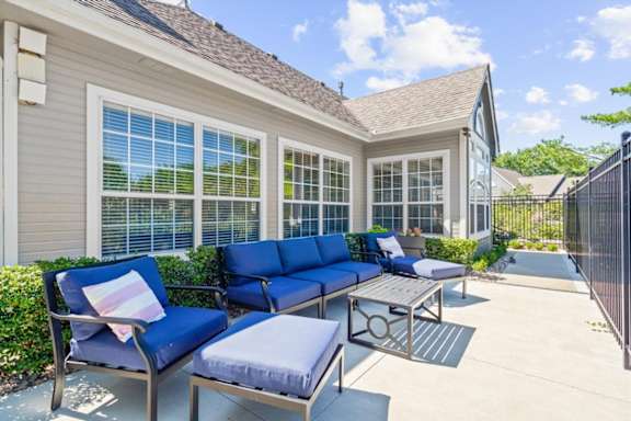 A blue couch and chair set is on a patio.