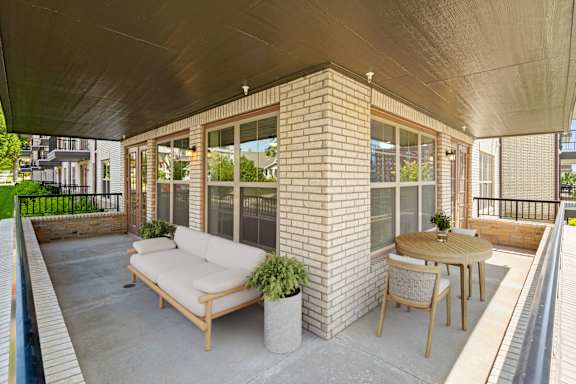 A large, private fenced-in balcony with a corner wall and large windows.