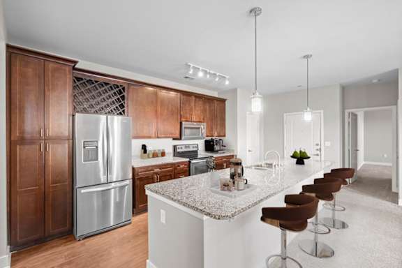 A modern kitchen with a refrigerator, microwave, and stove top oven.