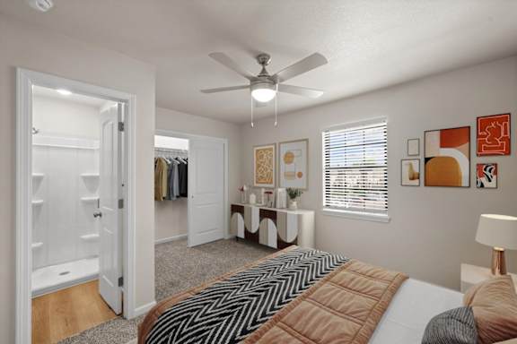 A bedroom with a large bed and a ceiling fan.