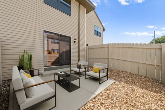 the backyard has a patio with furniture and a fence