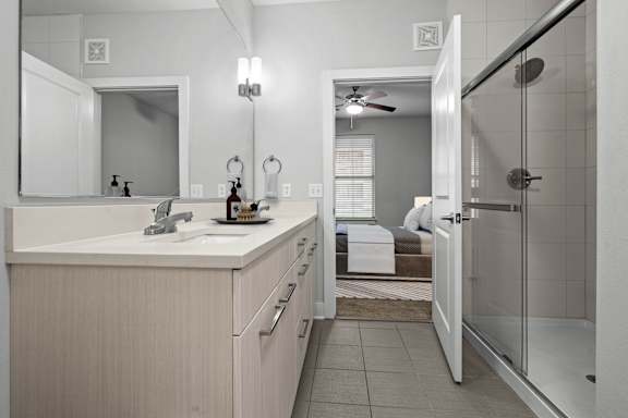 A bathroom with a white sink and a mirror above it.