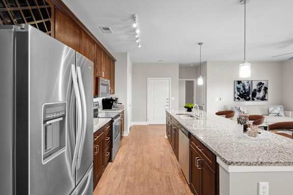 A modern kitchen with a stainless steel refrigerator and wooden cabinets.