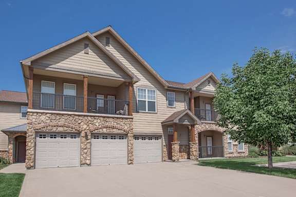 The exterior of an apartment building with garages, balconies and patios.