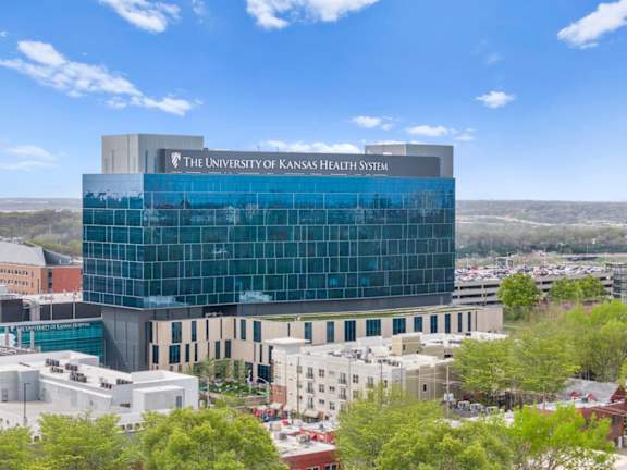 The University of Kansas Health System building is a large, modern structure with a glass facade.