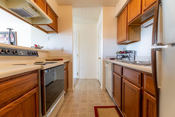 Kitchen with appliances, wooden cabinets, sink and granite counter tops4 at Coventry Oaks Apartments, Overland Park, KS