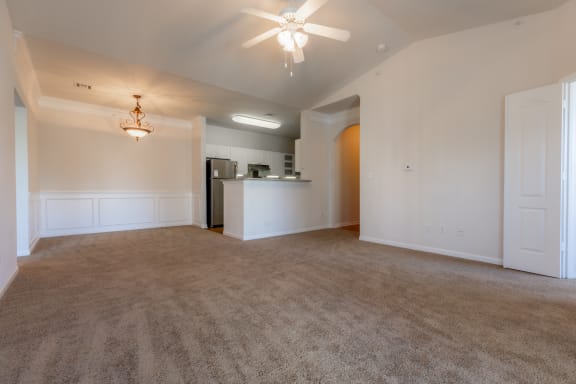 Wooden flooring with ceiling fan and light in living room and kitchen at Wynnewood Farms Apartments, Overland Park