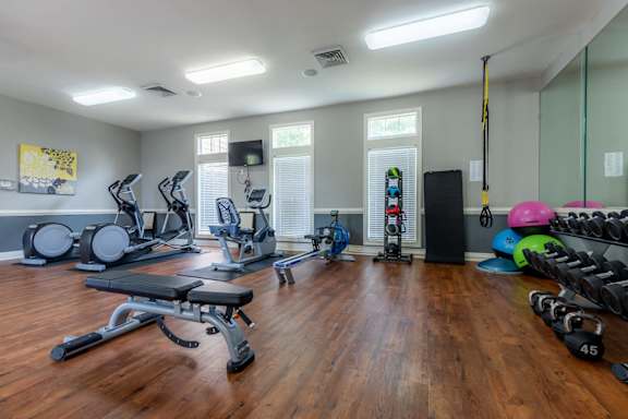 Fitness Center with exercise equipment, a weight bench, medicine balls, yoga balls, free weights, and more at Stonebriar Woods.