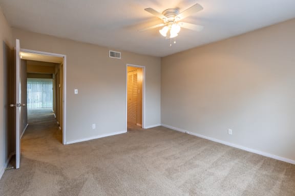 a bedroom with carpet and a ceiling fan