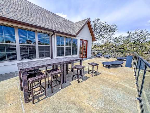 Rooftop terrace at The Dorset Apartments featuring dining tables, lounge chairs, and scenic city views.