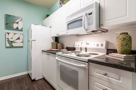 kitchen displaying refrigerator, stove and microwave within two bedroom floorplan at Wade Crossing Apartment Homes , Frisco, Texas