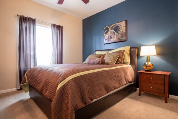 primary bedroom with furniture within two bedroom apartment at Wade Crossing Apartment Homes , Frisco, Texas,TX