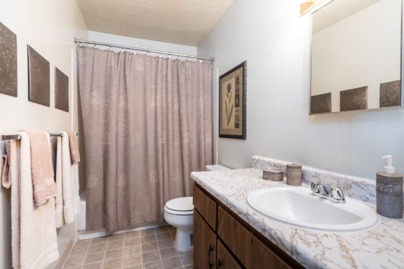 Bathroom with sink, mirror and toilet at Cloverset Valley Apartments, Kansas City, 64114