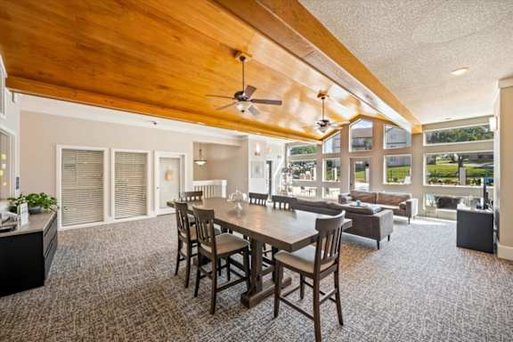Open clubhouse area with dining seating, natural light, and views of outdoor amenities.