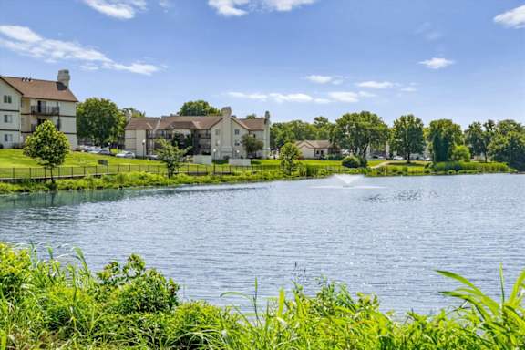 Lakefront view showcasing apartment homes, landscaped lawns, and waterfront scenery.