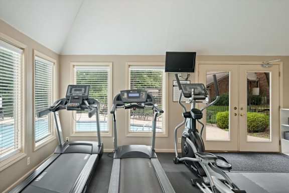 A home gym with treadmills and elliptical machines.
