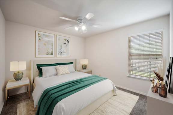 A bedroom with a large bed and a ceiling fan.