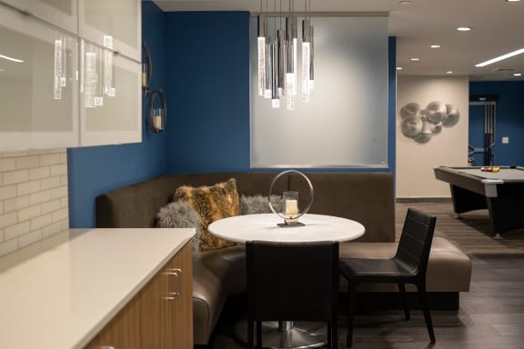 a dining area with a table and chairs and a pool table in the background at Sky on Main in Kansas City Downtown