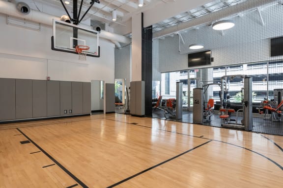 a basketball court in a gym with a basketball hoop and weights at Sky on Main in Kansas City, 64105