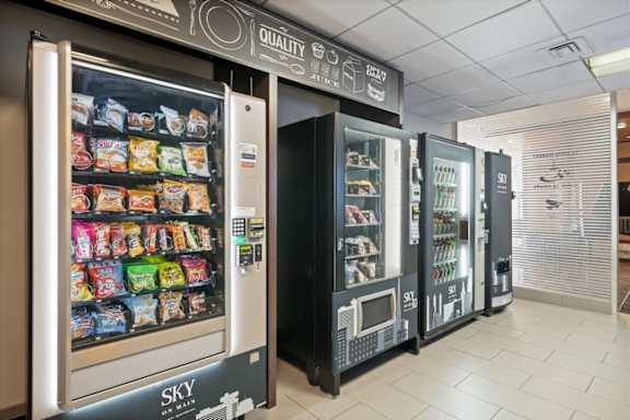 On-site micro market at Sky on Main featuring beverage vending machines, grab-and-go snacks, an ATM, and coffee service.