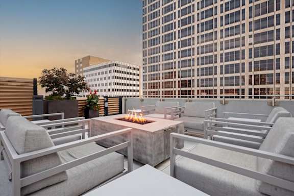 Rooftop gathering space at Sky on Main featuring modern lounge furniture, fire pit seating, and skyline views.