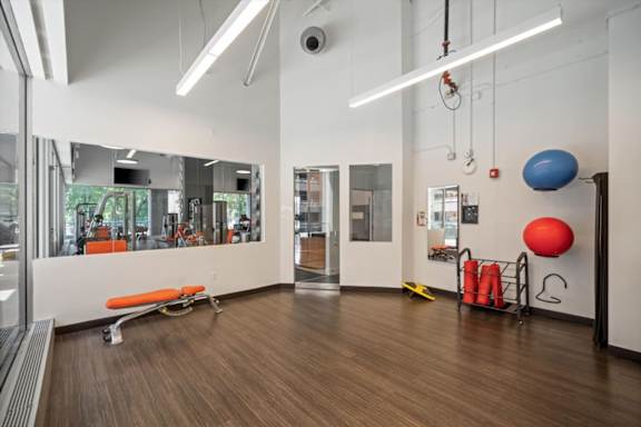Yoga and fitness studio at Sky on Main with mirrored walls, fitness equipment, high ceilings, and dedicated exercise space.