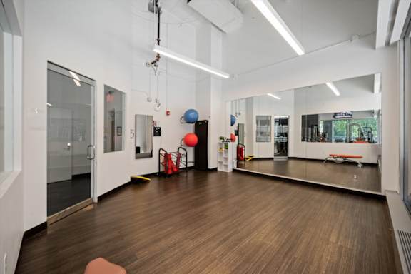 Fitness and yoga studio at Sky on Main with open workout space, mirrored walls, exercise accessories, and modern industrial design.