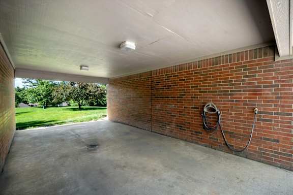 Covered car wash bay with hose hookup at Stonebriar Apartments in Overland Park