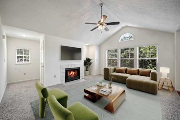 Living room with fireplace, vaulted ceiling, and large windows at Stonebriar Apartments