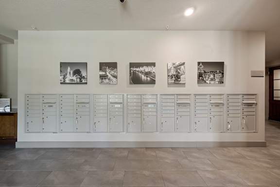 A wall with a row of mailboxes and pictures above it.