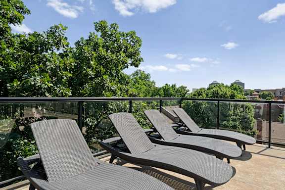 Rooftop patio at The Dorset with lounge chairs overlooking trees and surrounding neighborhood views
