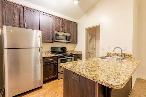 A kitchen with granite countertops and stainless steel appliances.