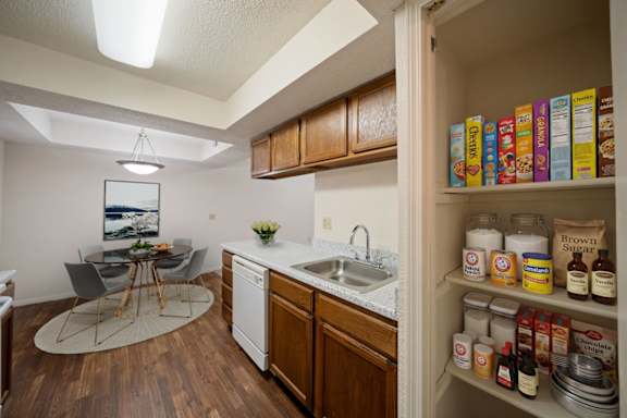 A kitchen pantry with a dining room table in the background