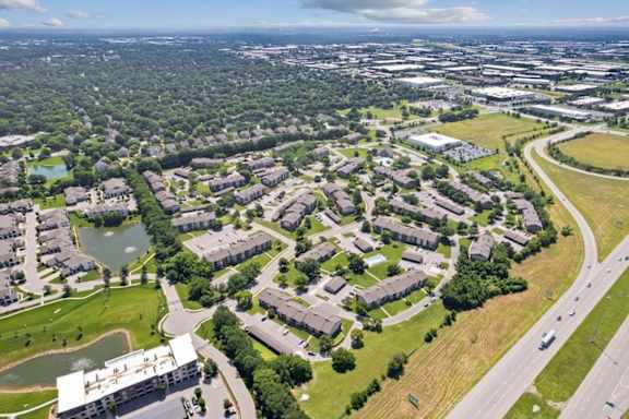 Bird's-eye view of Wind River Lodge Apartments showcasing residential buildings, community amenities, nearby ponds, and surrounding Lenexa neighborhoods.