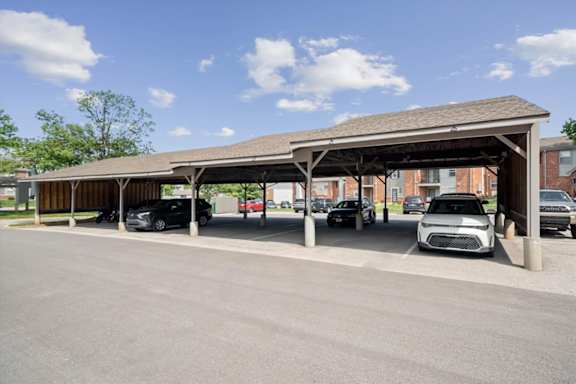 Covered resident parking carports at Wind River Lodge Apartments with reserved parking spaces and apartment homes visible in the background.